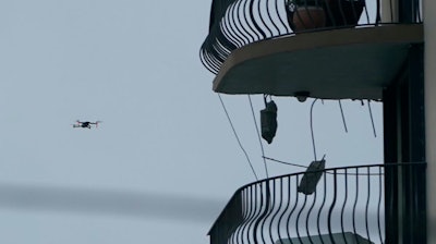 Search and rescue personnel use a drone to inspect the upper floors of the remaining portion of the Champlain Towers South Condo building.