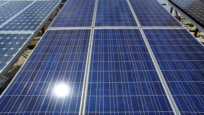 Sunlight reflects off solar panels on the roof of the older part of the Alabama Power building in Birmingham, Ala., Aug. 9, 2012.