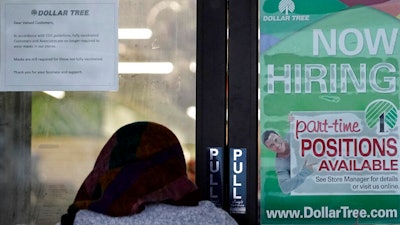 A shopper enters a retail store as a hiring sign shows in Buffalo Grove, IL on June 24.