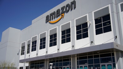 A worker walks out of an Amazon Fulfillment Center, Wednesday, March 31, 2021, in North Las Vegas. Amazon said it will stop testing its workers for COVID-19 at its warehouses at the end of July, citing the availability of vaccines and free testing.
