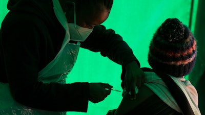 In this June 3, 2021 file photo an elderly patient receives a dose of the Pfizer COVID-19 vaccine, at a clinic at Orange Farm, near Johannesburg.