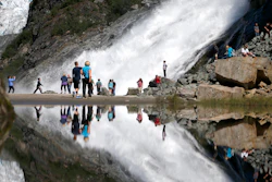 In this July 31, 2013, file photo, tourists visiting the Mendenhall Glacier in the Tongass National Forest are reflected in a pool of water as they make their way to Nugget Falls in Juneau, Alaska. The Biden administration said Thursday, July 15, 2021, that it is ending large-scale, old-growth timber sales on the nation's largest national forest.