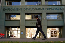 In this Dec. 18, 2020, file photo, a person passes the office of the California Employment Development Department in Sacramento, Calif. The recession that broke out with onset of the coronavirus pandemic officially ended in April 2021, making it the shortest downturn on record, according to the committee of economists that determines when recessions begin and end.