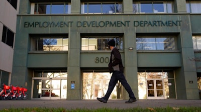 In this Dec. 18, 2020, file photo, a person passes the office of the California Employment Development Department in Sacramento, Calif. The recession that broke out with onset of the coronavirus pandemic officially ended in April 2021, making it the shortest downturn on record, according to the committee of economists that determines when recessions begin and end.