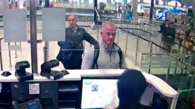 This Dec. 30, 2019 image from security camera video shows Michael L. Taylor, center, and George-Antoine Zayek at passport control at Istanbul Airport in Turkey. The trial in Tokyo of two Americans, Taylor and his son Peter Taylor, charged with helping Nissan’s former chairman, Carlos Ghosn, flee Japan wrapped up Friday, July 2, 2021 with prosecutors seeking prison terms of more than two years for each of them.