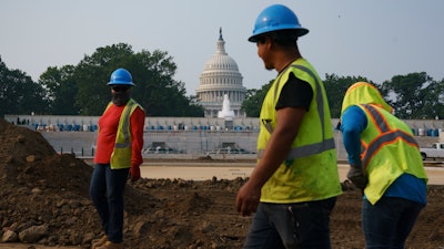 Workers repair a park near the Capitol in Washington, Wednesday, July 21, 2021. About 8 in 10 Americans favor plans to increase funding for roads, bridges and ports and for pipes that supply drinking water.
