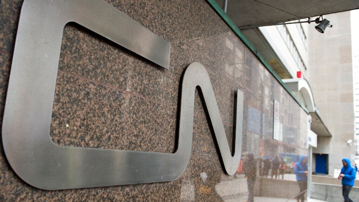 In this May 13, 2021, file photo, a man walks into Central Station next to Canadian National headquarters in Montreal. Kansas City Southern railroad is trying to keep its $33.6 billion merger with Canadian National on track by rejecting a competing $31 billion bid from rival Canadian Pacific earlier this week. Kansas City Southern said Thursday, Aug. 12, 2021, that its board unanimously decided to continue backing Canadian National's higher offer.