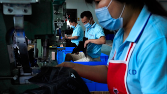 In this July 15, 2021, file photo, workers wearing face masks to help curb the spread of the coronavirus assembly ice-skating shoes at a manufacturing factory in the ice and snow sports equipment industry park in Zhangjiakou in northwestern China's Hebei province. China&rsquo;s factory activity decelerated in August as export demand weakened, a survey showed Tuesday, Aug. 31, 2021. The monthly purchasing managers&rsquo; index of the Chinese statistics bureau and an official industry group declined to 50.1 from July&rsquo;s 50.4 on a 100-point scale on which numbers above 50 show activity increasing.