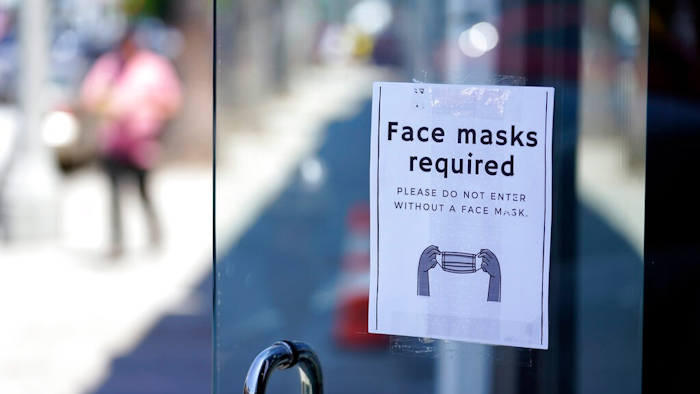 A sign advises shoppers to wear masks outside of a story Monday, July 19, 2021, in the Fairfax district of Los Angeles. Los Angeles County has reinstated an indoor mask mandate due to rising COVID-19 cases.
