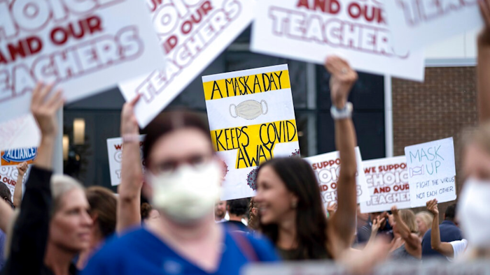 People in favor of and against a mask mandate for Cobb County schools gather and protest ahead of the school board meeting Thursday, Aug. 19, 2021, in Marietta, Ga.