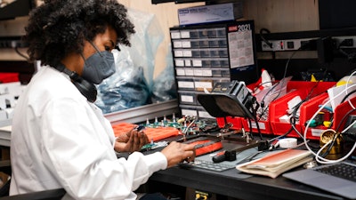 In this April 28 photo, an employee manually assembles a circuit-board element before a ribbon-cutting ceremony to mark the opening of a Nanotronics manufacturing center at the Brooklyn Navy Yard in the Brooklyn borough of New York.