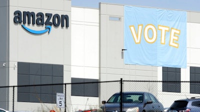 In this March 30, 2021 file photo, a banner encouraging workers to vote in labor balloting is shown at an Amazon warehouse in Bessemer, Ala. The union that tried, and failed, to organize Amazon warehouse workers in Bessemer, says it may get a do-over. The Retail, Wholesale and Department Store Union on Monday, Aug. 2 said that a hearing officer for the National Labor Relations Board has recommended that the vote by workers in April to overwhelmingly reject the union be set aside and that another vote be held in its place.