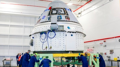 In this June 2, 2021 photo made available by NASA, technicians prepare Boeing's CST-100 Starliner for the company's Orbital Flight Test-2 (OFT-2) in the Commercial Crew and Cargo Processing Facility at NASA's Kennedy Space Center in Florida. On Friday, Aug. 13, 2021, Boeing and NASA officials said the capsule is grounded for months and possibly even until next year because of a vexing valve problem.