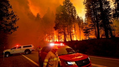 Flames leap from trees as the Dixie Fire jumps Highway 89 north of Greenville in Plumas County, Calif., on Tuesday, Aug. 3, 2021. Dry and windy conditions have led to increased fire activity as firefighters battle the blaze which ignited July 14.