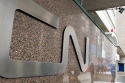 In this May 13, 2021, file photo, a man walks into Central Station next to Canadian National headquarters in Montreal. Kansas City Southern railroad is trying to keep its $33.6 billion merger with Canadian National on track by rejecting a competing $31 billion bid from rival Canadian Pacific earlier this week. Kansas City Southern said Thursday, Aug. 12, 2021, that its board unanimously decided to continue backing Canadian National's higher offer.