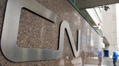 In this May 13, 2021, file photo, a man walks into Central Station next to Canadian National headquarters in Montreal. Kansas City Southern railroad is trying to keep its $33.6 billion merger with Canadian National on track by rejecting a competing $31 billion bid from rival Canadian Pacific earlier this week. Kansas City Southern said Thursday, Aug. 12, 2021, that its board unanimously decided to continue backing Canadian National's higher offer.