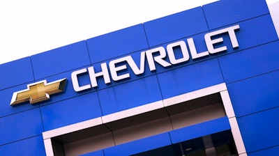 The Chevrolet logo is displayed on the facade of a dealership , Tuesday, Aug. 3, 2021, in Woburn, Mass. Despite a computer chip shortage that temporarily closed some of its factories, General Motors made a healthy $2.8 billion second-quarter net profit in the second quarter.