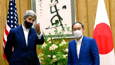 U.S. Special Presidential Envoy for Climate John Kerry, left, gestures to Japanese Prime Minister Yoshihide Suga during a meeting at Suga's official residence in Tokyo Tuesday, Aug. 31, 2021. Kerry met with Japan's top diplomat to push efforts to fight climate change ahead of a United Nations conference in November.