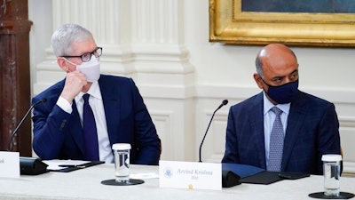 Apple CEO Tim Cook, left, and IBM CEO Arvind Krishna listen as President Joe Biden speaks during a meeting about cybersecurity in the East Room of the White House, Wednesday, Aug. 25, 2021, in Washington.