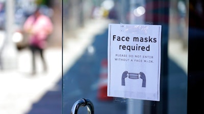 A sign advises shoppers to wear masks outside of a story Monday, July 19, 2021, in the Fairfax district of Los Angeles. Los Angeles County has reinstated an indoor mask mandate due to rising COVID-19 cases.