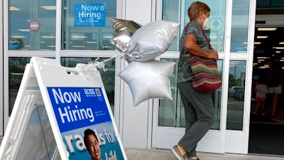 A shopper passes a hiring sign while entering a retail store in Morton Grove, Ill., Wednesday, July 21, 2021. Despite an uptick in COVID-19 cases and a shortage of available workers, the U.S. economy likely enjoyed a burst of job growth last month as it bounces back with surprising vigor from last year’s coronavirus shutdown. The Labor Department’s July jobs report Friday, Aug. 6 is expected to show that the United States added more than 860,000 jobs in July, topping June’s 850,000, according to a survey of economists by the data firm FactSet.