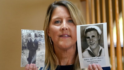 Teri Mann Whyatt displays photos of her uncle, William Edward Mann, who died on the USS Arizona during the bombing of Pearl Harbor, at her home Wednesday, July 14, 2021, in Newcastle, Wash. In recent years, the U.S. military has taken advantage of advances in DNA technology to identify the remains of hundreds of sailors and Marines who died in the 1941 bombing of Pearl Harbor.