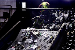 In this Thursday, Sept. 6, 2018, file photo, workers clean consumer plastic shopping bags from the clogged rollers of a machine which separates paper, plastic and metal recyclable material, in a processing building at EL Harvey & Sons, a waste and recycling company, in Westborough, Mass. States around the country are looking to adopt new recycling regimes that require producers of packaging to pay for its inevitable disposal.