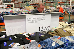 A sign displays the price for shirts as a shopper peruses the offerings at a Costco warehouse in this photograph taken Thursday, June 17, 2021, in Lone Tree, Colo. Growth in U.S. consumer spending slowed in July to a modest increase of 0.3% while inflation over the past 12 months rose to the fastest pace in three decades.