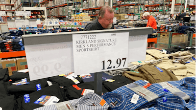 A sign displays the price for shirts as a shopper peruses the offerings at a Costco warehouse in this photograph taken Thursday, June 17, 2021, in Lone Tree, Colo. Growth in U.S. consumer spending slowed in July to a modest increase of 0.3% while inflation over the past 12 months rose to the fastest pace in three decades.