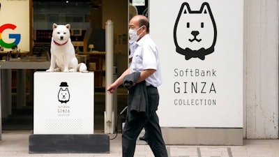 A man walks in front of a SoftBank shop in Tokyo on July 29, 2021. Japanese technology company SoftBank’s fiscal first quarter earnings dropped 39% because of the absence of the cash from selling Sprint, which boosted profits a year ago.