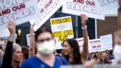 People in favor of and against a mask mandate for Cobb County schools gather and protest ahead of the school board meeting Thursday, Aug. 19, 2021, in Marietta, Ga.