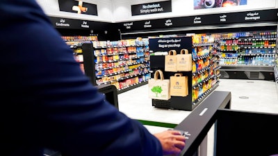 A man uses a QR code on a mobile phone to enter Carrefour's new cashier-less grocery store in Mall of the Emirates in Dubai, Sept. 6, 2021.