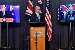 Australian Prime Minister Scott Morrison, center, appears on stage with video links to British Prime Minister Boris Johnson and President Joe Biden, Parliament House, Canberra, Sept. 16, 2021.