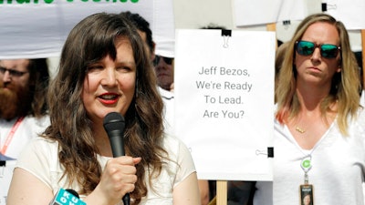 This May 22, 2019 file photo, Emily Cunningham, left, speaks as Kathryn Dellinger, right, looks on during a news conference following Amazon's annual shareholders meeting in Seattle. Amazon is settling with the two former tech workers who accused the company of illegally firing them last year for speaking out against the company. The former employees, Cunningham and Costa, publicly criticized the Seattle-based company and pushed Amazon to better protect warehouse workers from COVID-19.