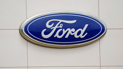 A Ford logo is seen on signage at Country Ford in Graham, N.C., Tuesday, July 27, 2021. Ford Motor Co. has hired a former executive from Apple and Tesla to be the company's head of advanced technology and new embedded systems, a critical post as the auto industry moves to adopt vehicles powered by electricity and guided by computers.