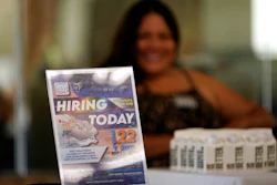 A hiring sign is placed at a booth for prospective employers during a job fair Wednesday, Sept. 22, 2021, in the West Hollywood section of Los Angeles. The number of Americans applying for unemployment aid rose last week for a second straight week to 351,000, a sign that the delta variant of the coronavirus may be disrupting the job market’s recovery, at least temporarily.