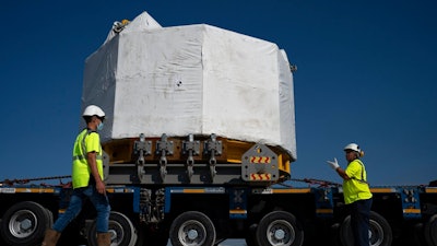 Workers secure a central solenoid magnet for the ITER project as it departs from Berre-l'Etang in southern France, Monday, Sept. 6, 2021. The first part of a massive magnet so strong its American manufacturer claims it can lift an aircraft carrier arrived Thursday, Sept. 9, 2021 at a high-security site in southern France, where scientists hope it will help them build a 'sun on earth.' Almost 60-feet tall and 14 feet in diameter when fully assembled, the magnet is a crucial component of the International Thermonuclear Experimental Reactor, or ITER, a 35-nation effort to develop an abundant and safe source of nuclear energy for future generations.