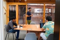 RunX CEO Ankur Dahiya, center, takes part in a meeting with employees Nitin Aggarwal, left, and JD Palomino, right, at a rented office in San Francisco, Friday, Aug. 27, 2021. The eight-worker startup rents the office one day a week so Dahiya can meet with remote working employees who live nearby but other employees are in Canada, Nevada, and Oregon.