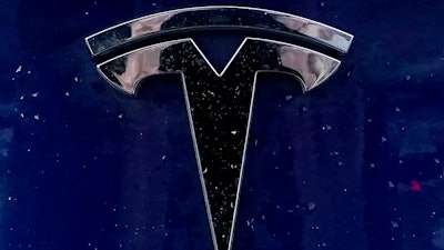 In this Feb. 21, 2021 file photo, a Tesla electric vehicle emblem is affixed to a passenger vehicle in Boston. The U.S. government’s highway safety agency wants detailed information on how Tesla’s Autopilot system detects and responds to emergency vehicles that are handling traffic crashes. The National Highway Traffic Safety Administration made the request in an 11-page letter to the electric car maker that was dated Tuesday, Aug. 31.