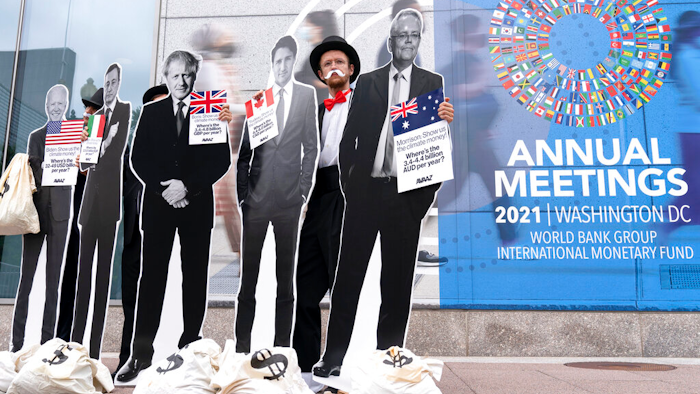 Activists holding a cardboard cutouts of President Joe Biden, Canadian Prime Minister Justin Trudeau, Australian Prime Minister Scott Morrison, Britain's Prime Minister Boris Johnson and Italian Prime Minister Mario Draghi protest outside of the International Monetary Fund headquarters during the World Bank/IMF Annual Meetings in Washington on Oct. 13, 2021.