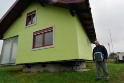 Vojin Kusic's stands in front of his rotating house in a town of Srbac, northern Bosnia, Sunday, Oct. 10, 2021.