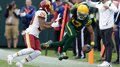 The Green Bay Packers' Davante Adams is pushed out of bounds by Washington's Kendall Fuller after making a catch, Lambeau Field, Green Bay, Wis., Oct. 24, 2021.