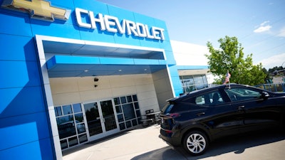 In this Sunday, Sept. 12, 2021, file photo, a pair of unsold 2022 Bolt electric vehicles sit outside a Chevrolet dealership in Englewood, Colo. U.S. new vehicle sales tumbled in September as a global shortage of computer chips worsened, shuttering factories and limiting the selection on dealer lots.