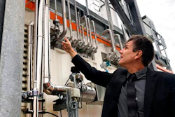 Dietrich Brockhagen, Executive Director of Atmosfair, points on pipes of the system that brings hydrogen and carbon into the facility that mix them and produce e-fuel at the 'Atmosfair' synthetic kerosene plant in Werlte, Germany, Monday, Oct. 4, 2021. German officials are unveiling a facility in Werlte, near Germany's northwestern border with the Netherlands, what they say will be the world's first commercial plant for making synthetic kerosene as part of an effort to reduce the climate impact of flying.