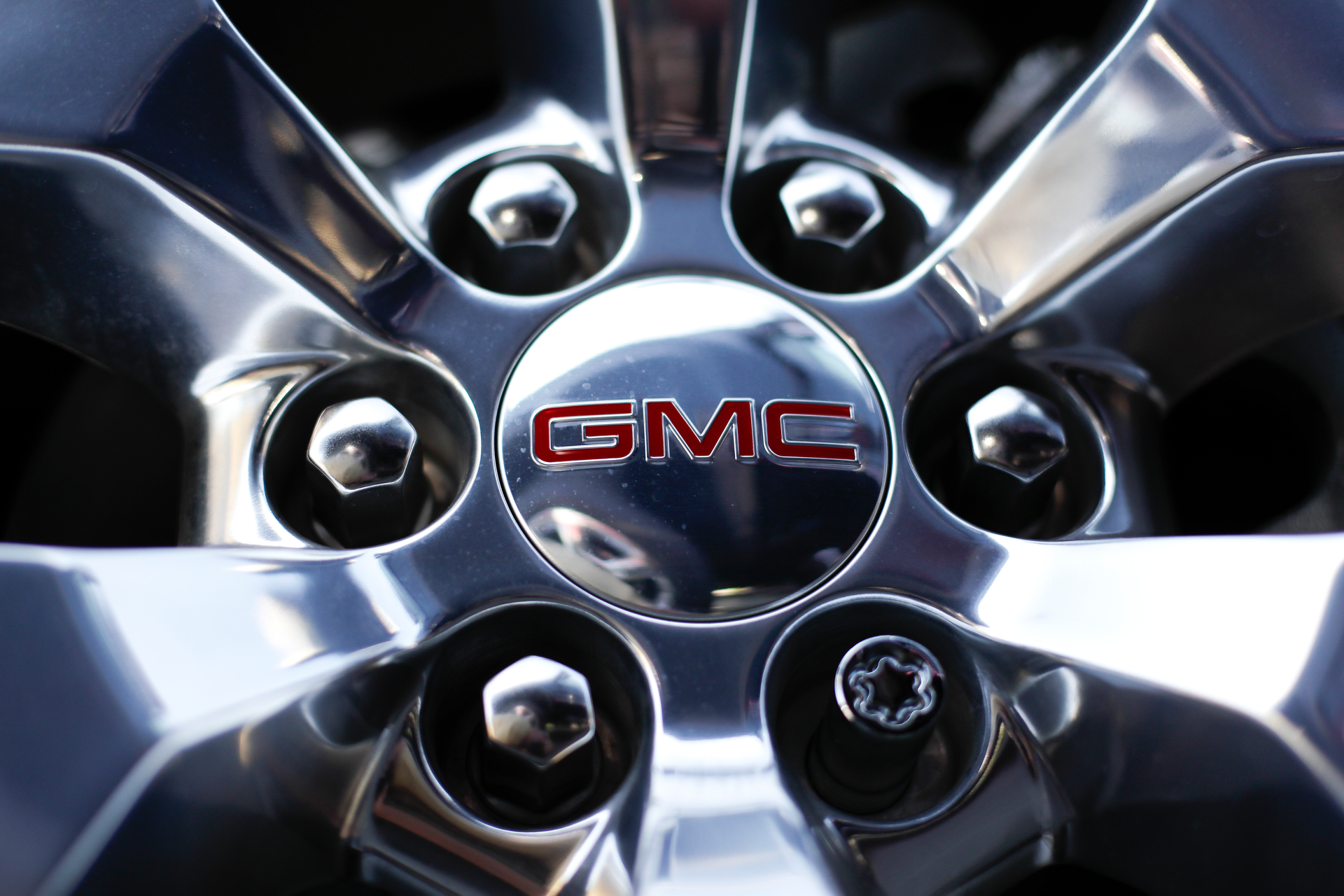 In this April 25, 2017 file, photo, a GMC logo is displayed on the wheel of a truck at a General Motors dealer's lot in Nashville, Tenn. General Motors plans to cash in as the world switches from combustion engines to battery power, promising to double its annual revenue by 2030 with an array of new electric vehicles, profitable gas-powered cars and trucks, and services such as an electronic driving system that can handle most tasks on the road.