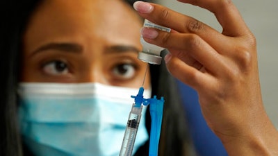 In this May 19, 2021, file photo, a licensed practical nurse draws a Moderna COVID-19 vaccine into a syringe at a mass vaccination clinic at Gillette Stadium in Foxborough, Mass. Starting Thursday, Oct. 14, 2021, the Food and Drug Administration convenes its independent advisers for the first stage in the process of deciding whether extra shots of Moderna or Johnson & Johnson vaccines should be dispensed and, if so, who should get them and when.