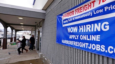 In this Dec. 10, 2020, file photo, a 'Now Hiring' sign hangs on the front wall of a Harbor Freight Tools store in Manchester, N.H. When the U.S. government issues the September jobs report on Friday, Oct. 8, 2021, the spotlight will fall not only on how many people were hired last month. A second question will command attention, too: Are more people finally starting to look for work?