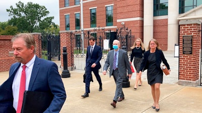 Former SCANA CEO Kevin Marsh, center, walks out of a courtroom with his lawyers after being sentenced to two years in prison for lying and deceiving the public about the progress of a pair of nuclear reactors in South Carolina that were never finished and wasted billions of dollars on Thursday, Oct. 7, in Columbia, S.C. Marsh also has pleaded guilty in state charges in the case.
