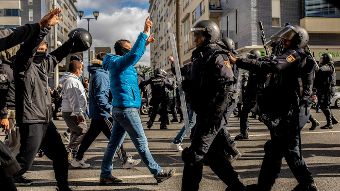 Protesters, left, march during a strike organized by metal workers in Cadiz, southern Spain, Tuesday, Nov. 23, 2021.
