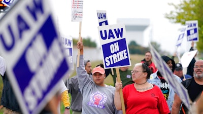 Members of the United Auto Workers strike outside of a John Deere plant on Oct. 20, 2021 in Ankeny, IA.